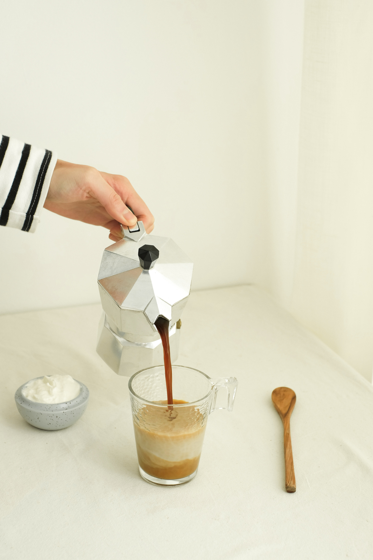 Hand Pouring Coffee into Glass Mug